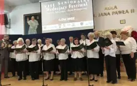 Seniorzy z Dziennego Domu na scenie w trakcie śpiewu