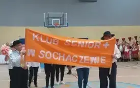 Uczestnicy Klubu Senior+ z banerem "Klub Senior+ w Sochaczewie" w hali MOSiR 