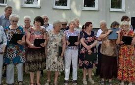Grupa uczestnik&oacute;w pikniku przed budynkiem DDPS podczas występu